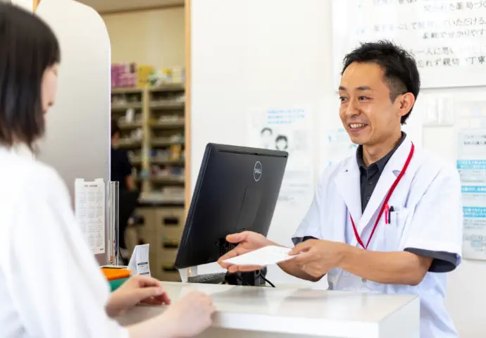 処方箋を渡している男性薬剤師